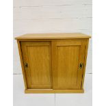 Oak low wardrobe with two sliding doors.