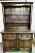 1930's oak dresser with two open shelves above two frieze drawers with two cupboards beneath.