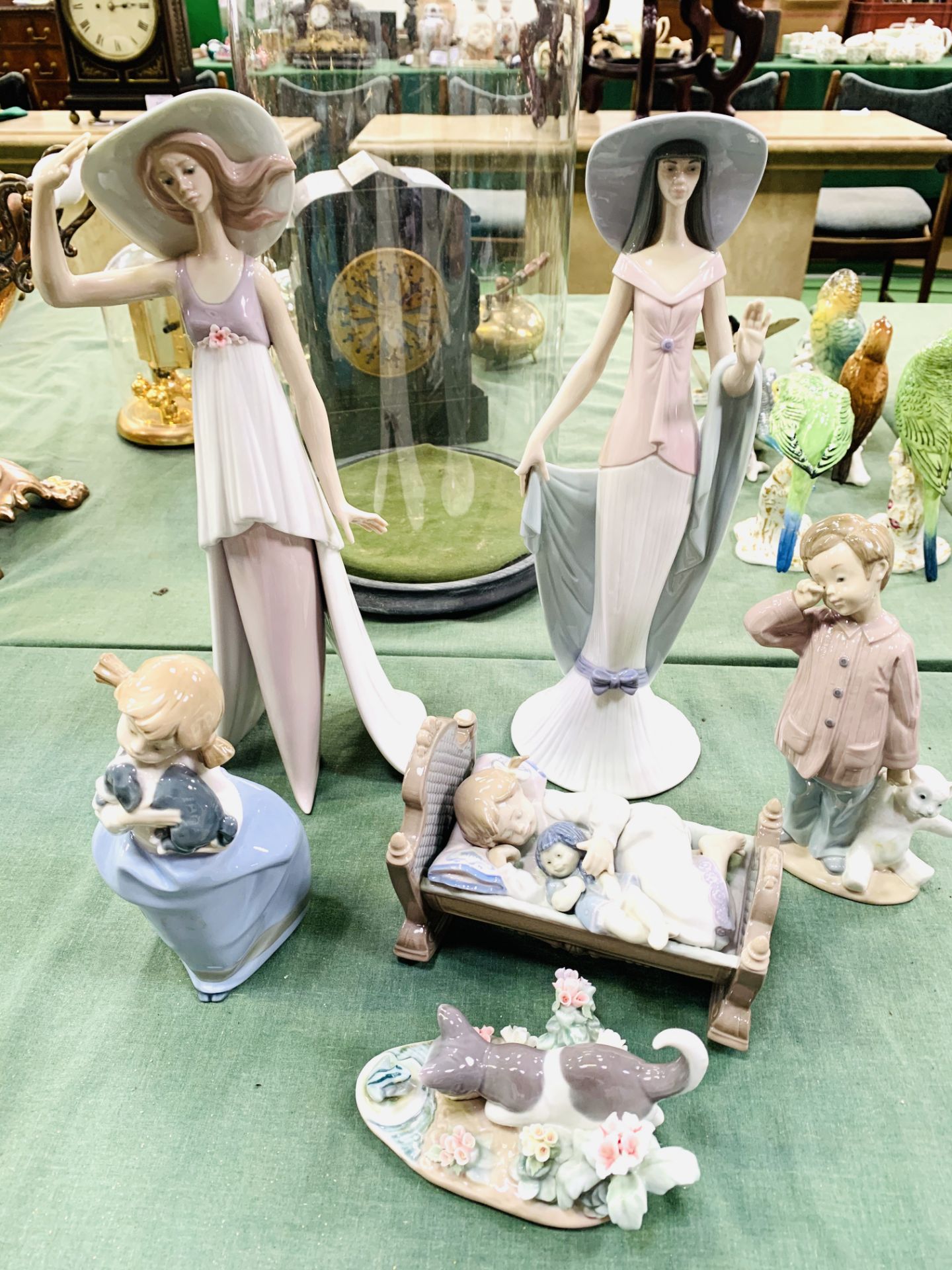 Four Lladro figurines and two Nao figurines.