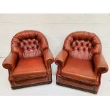 Pair of button back red leather arm chairs with studded trim to arms and back.