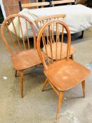 Three stick-back dining chairs.
