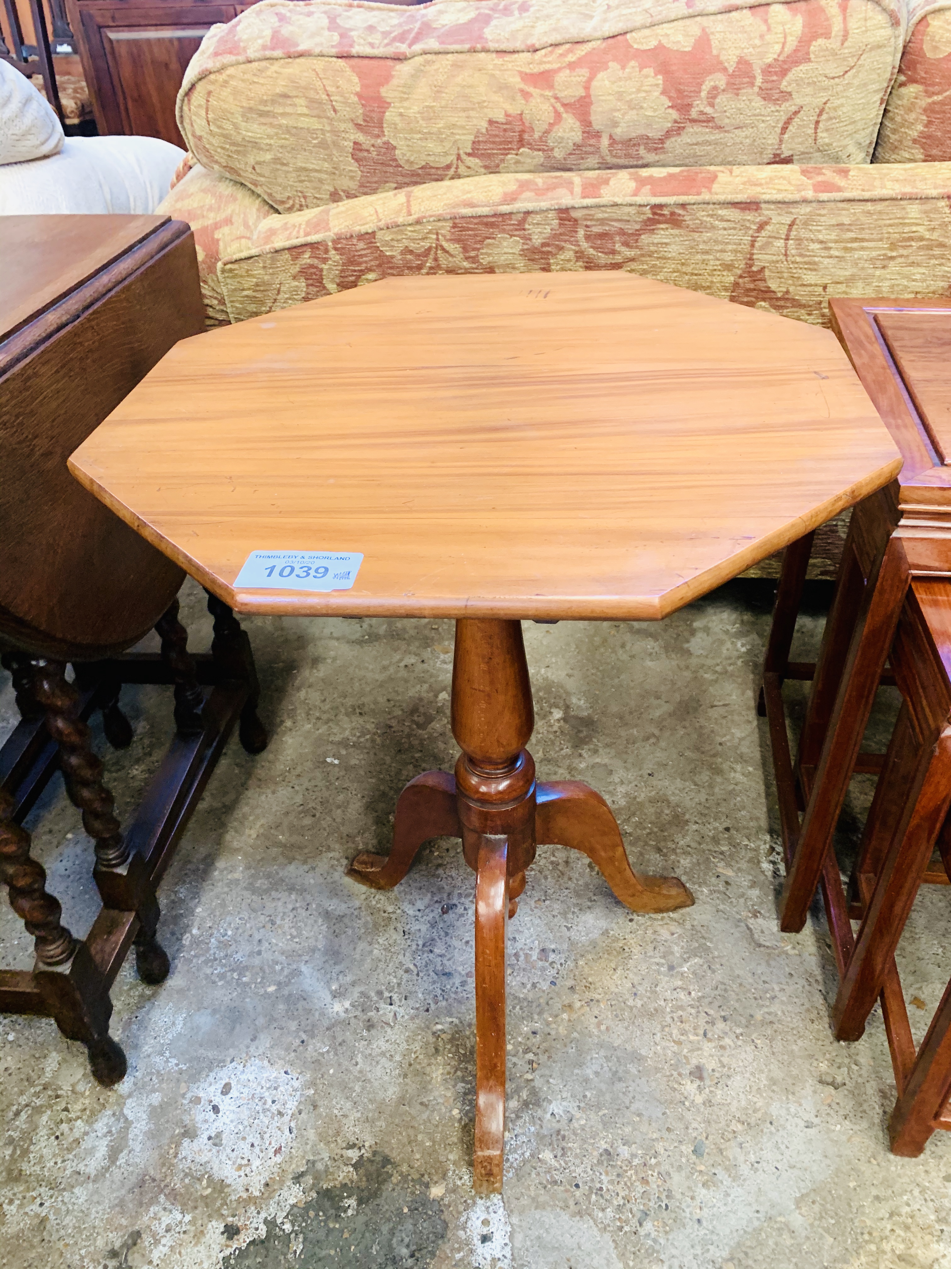 Octagonal tilt-top wine table on pedestal to three feet.