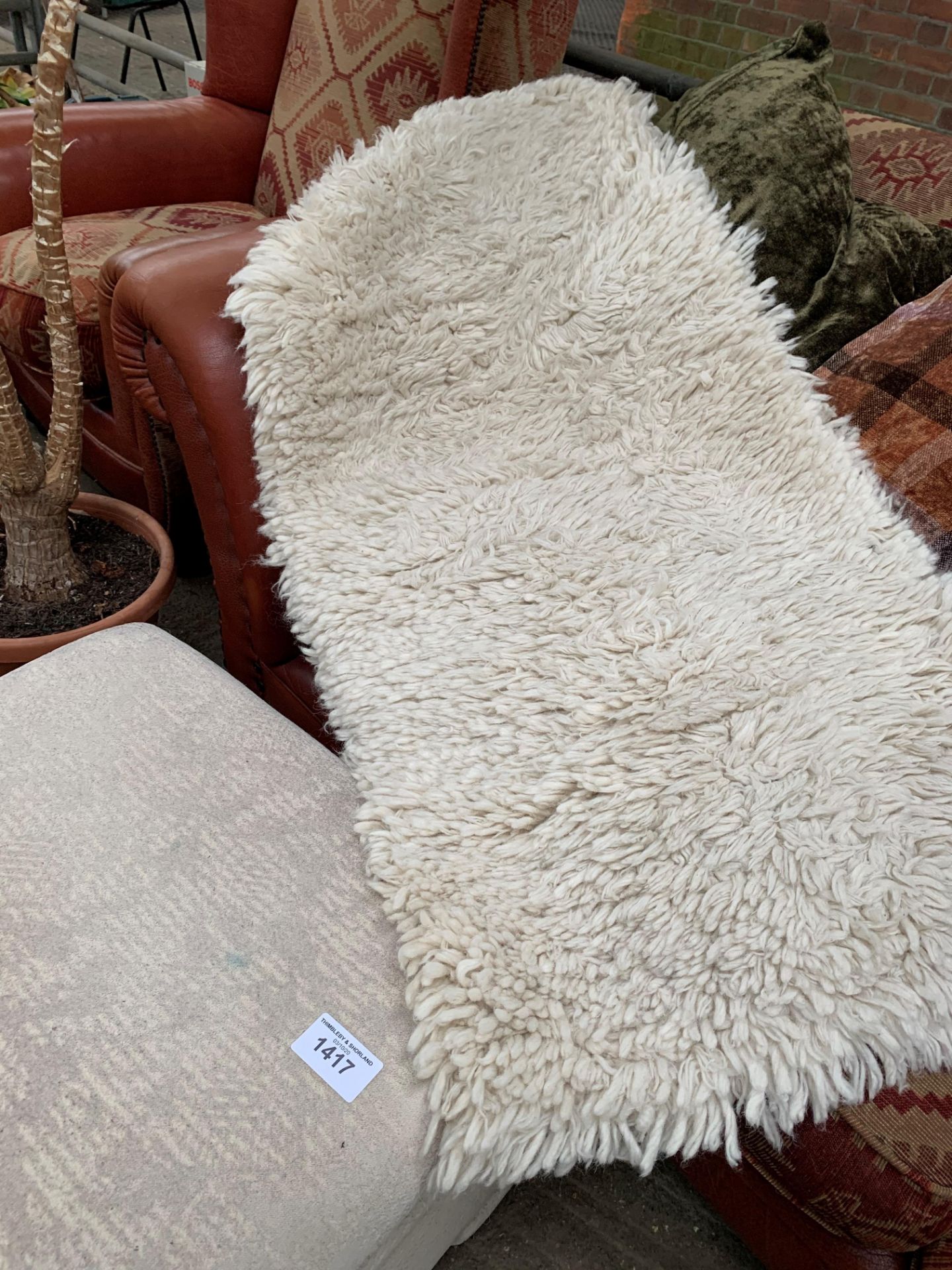 Shag pile rug and a cream upholstered ottoman