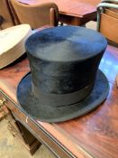 Black silk top hat in cardboard hat box.