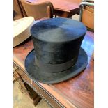 Black silk top hat in cardboard hat box.