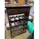 Wooden bottle rack with drawer at top.