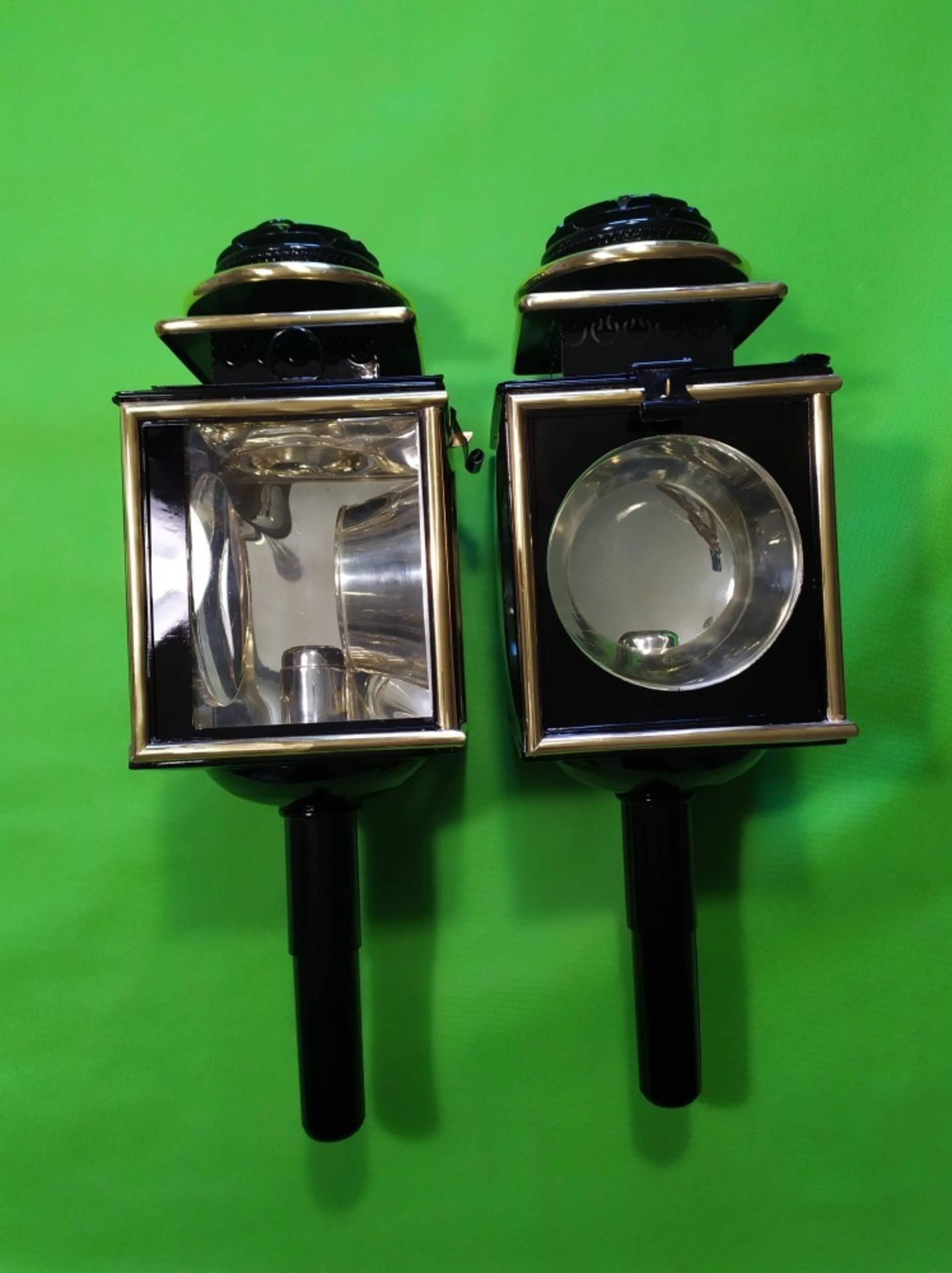 Pair of new black/brass Coach lamps with silvered interiors measuring 54cms long.