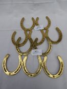 Two sets of brass horse shoes fixed together