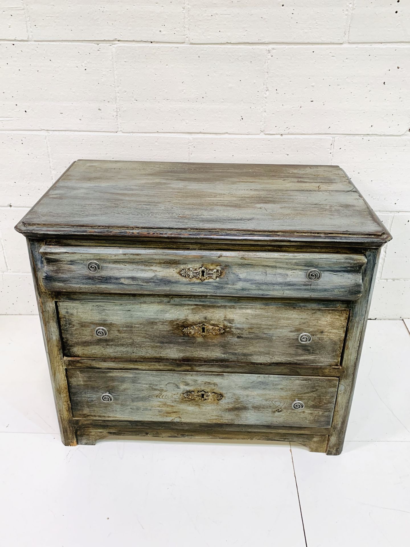 Painted antique pine chest of three graduated drawers.