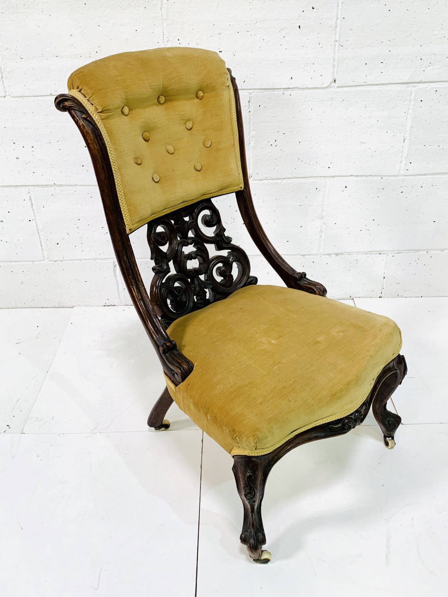 Ornately decorated mahogany framed drawing room chair with buttoned back mustard upholstrey.