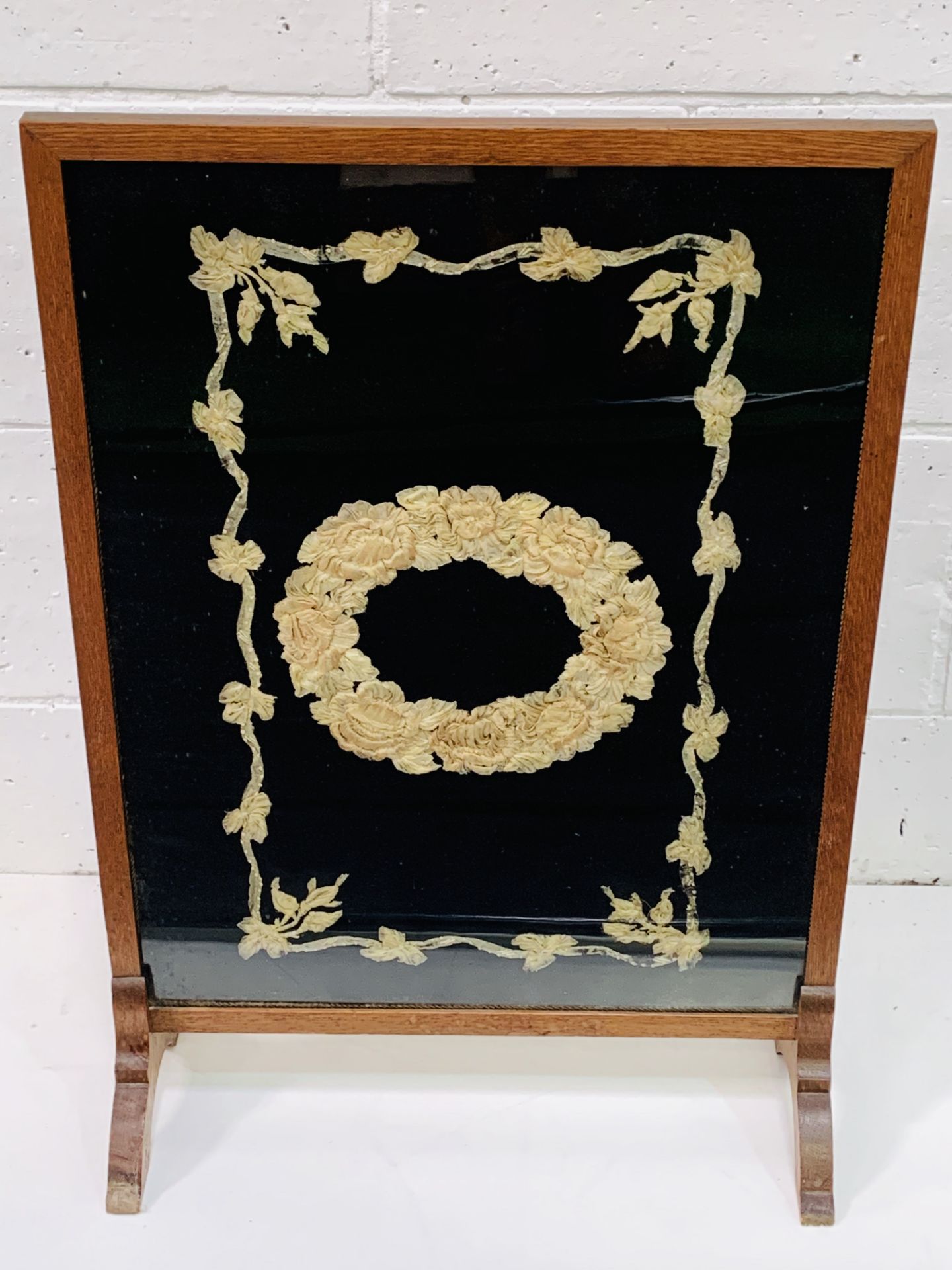 Oak framed fire screen with silk decoration behind perspex.