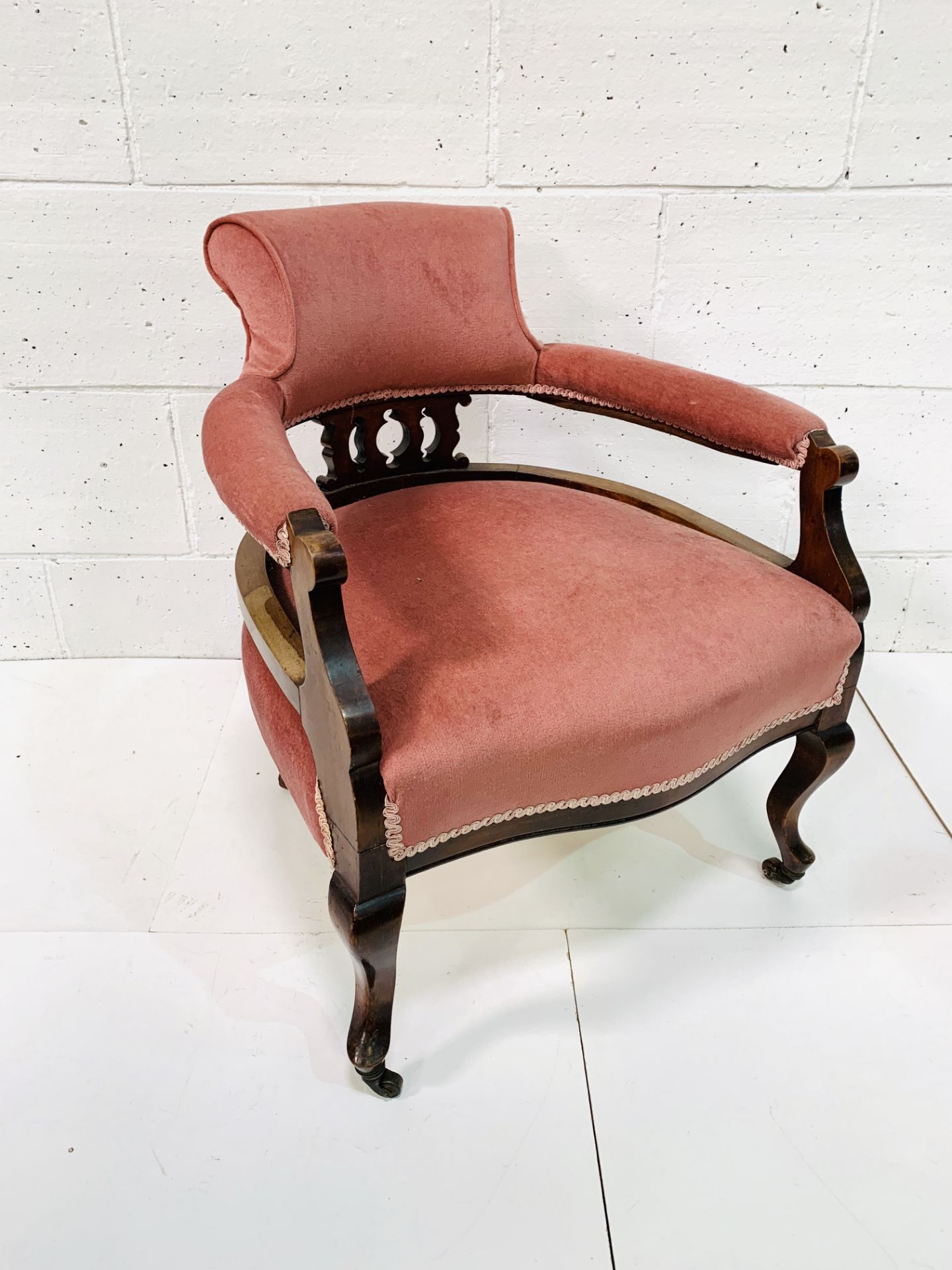 Mahogany pink velvet upholstered open arm chair with shaped legs.