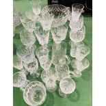 Quanity of cut glass drinking glasses together with a cut glass fruit bowl.