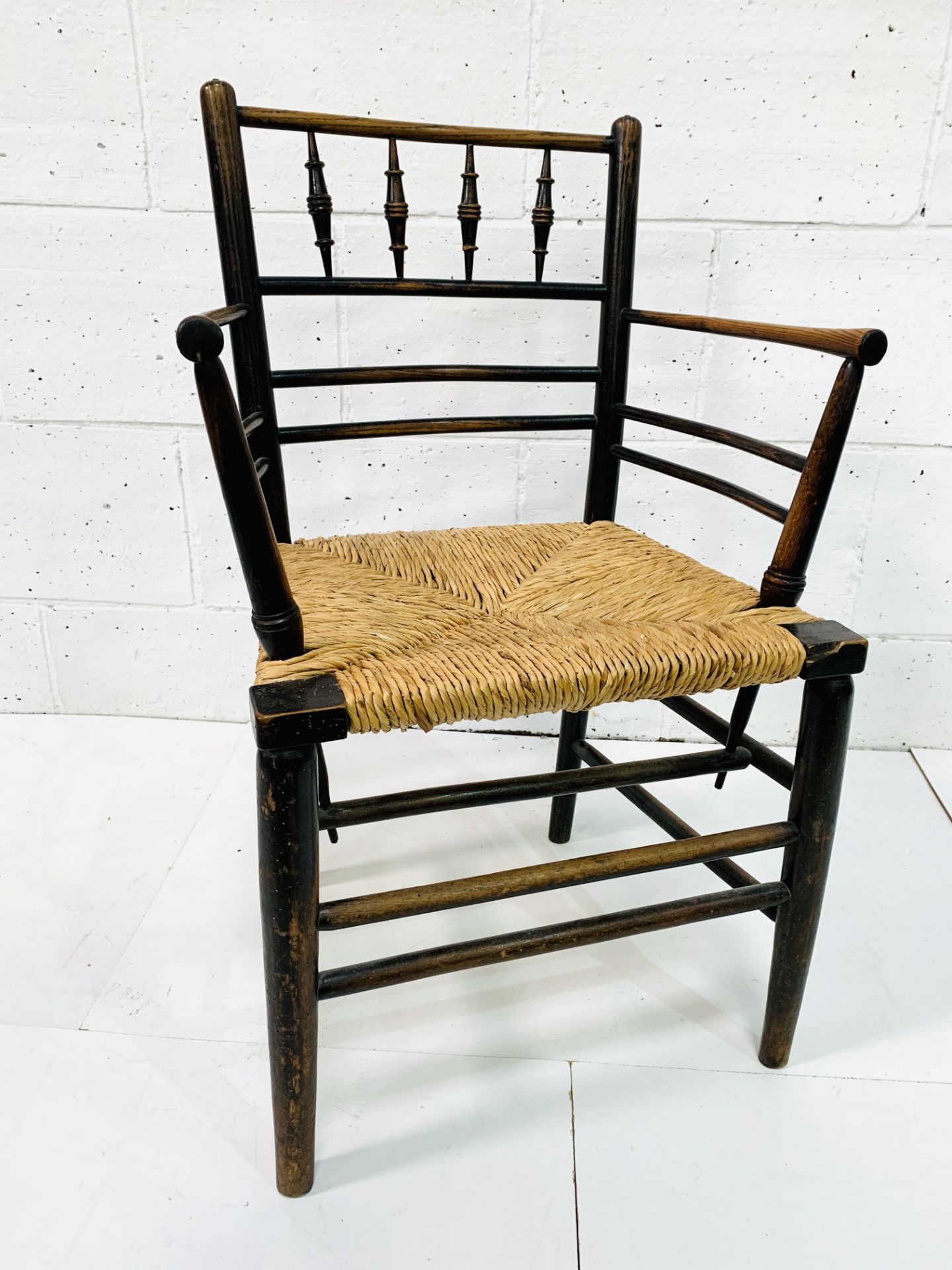 A late Victorian Morris & Co. ‘Sussex’ chair oak framed rail back open arm chair.