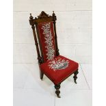 Carved mahogany framed high back hall chair with bead embroidered seat and back on ceramic casters.