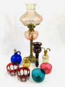 Brass oil lamp with pale pink shade; pair of ruby cut bowls and a glass; and other glass ware