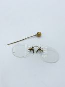 A pair of pince-nez and a gold or gold plated hat pin