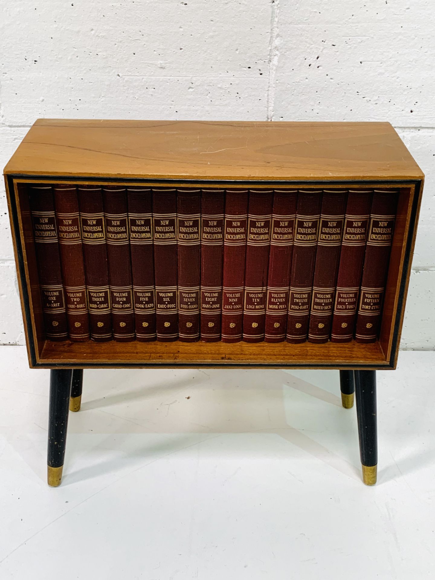 Teak small 1950's bookcase on legs with a complete set of the New Universal Encyclopedia.