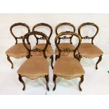 Set of six mahogany balloon back dining chairs with pink upholstered seats and carved top rail.