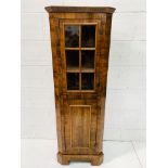 Walnut corner cabinet with glazed cupboard top and shape fronted shelves above cupboard.