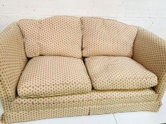 Cream and pink upholstered sofa withfeather-filled cushions.