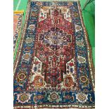 Red and brown ground hand knotted Middle Eastern rug.