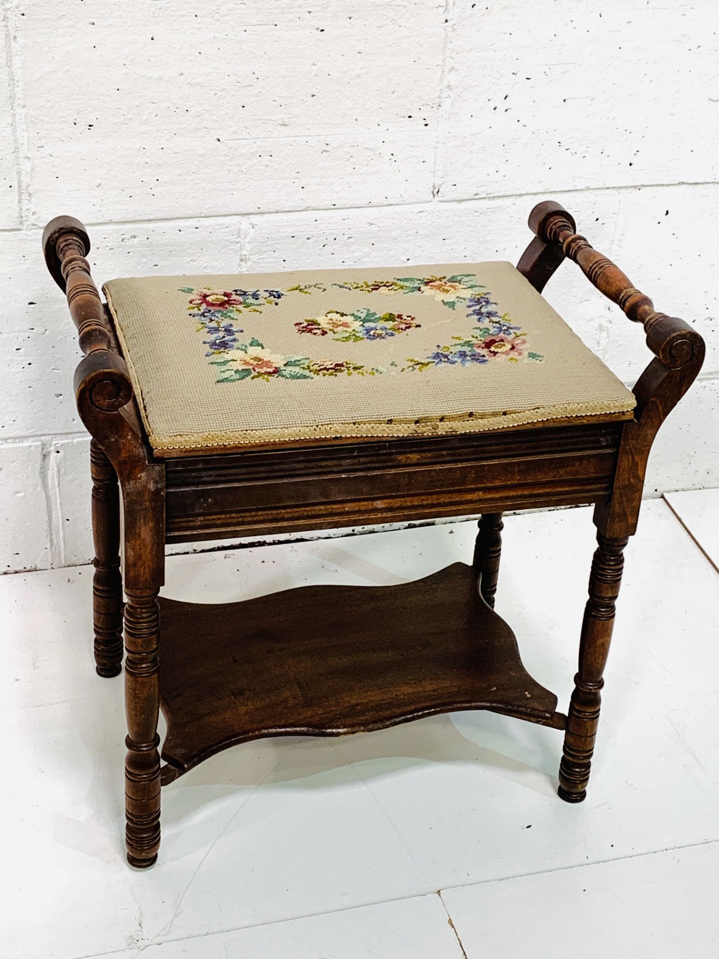 Oak framed stool with tapestry upholstered lifting seat and shelf beneath.