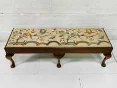 Oak framed long stool with tapestry seat depicting flowers.