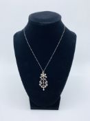 Diamond and pearl pendant on a platinum chain. Length of pendant 47.2 mms. Length of chain 40 cms