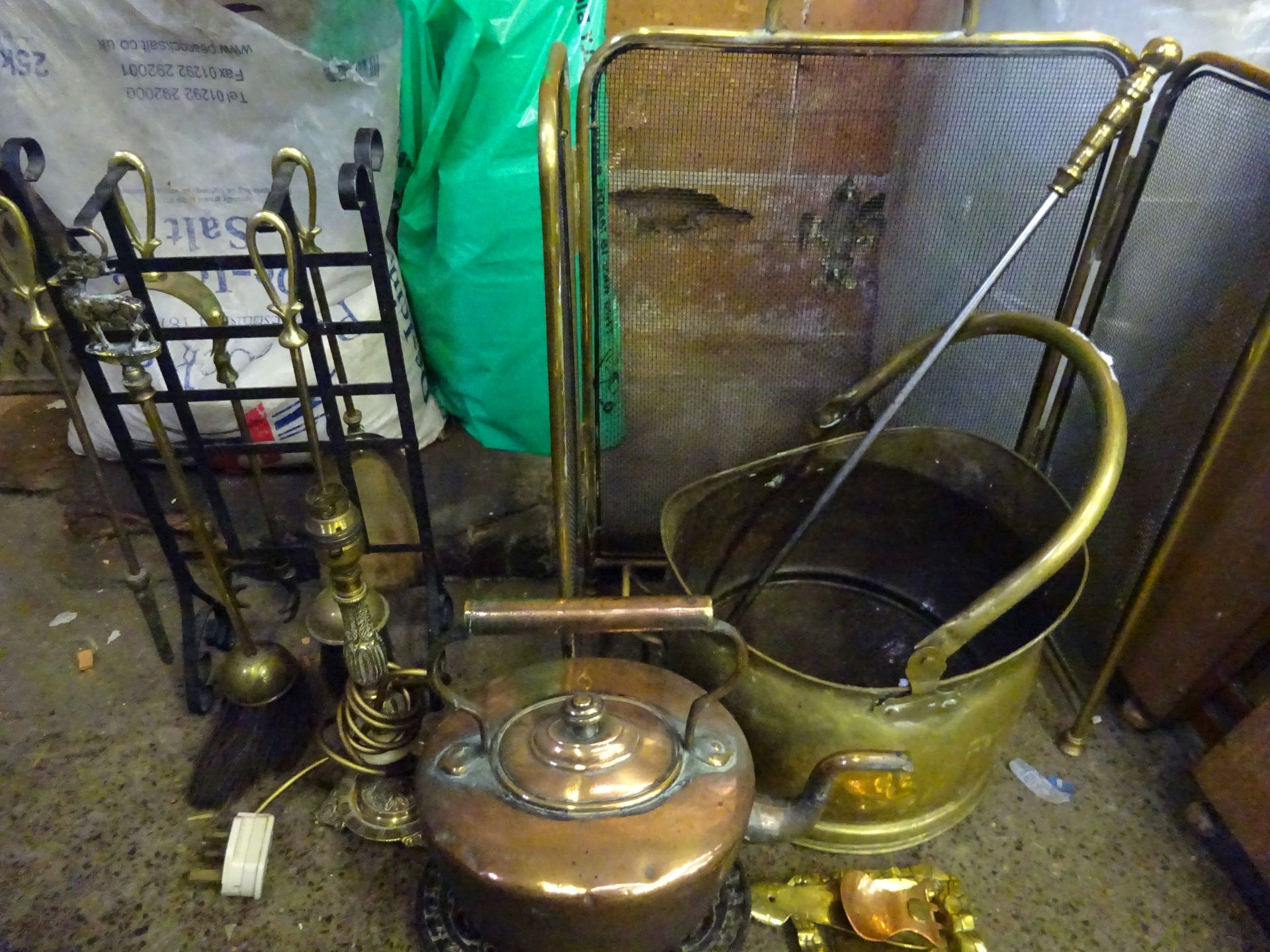 Copper kettle, brass frame spark guard, brass table lamp.