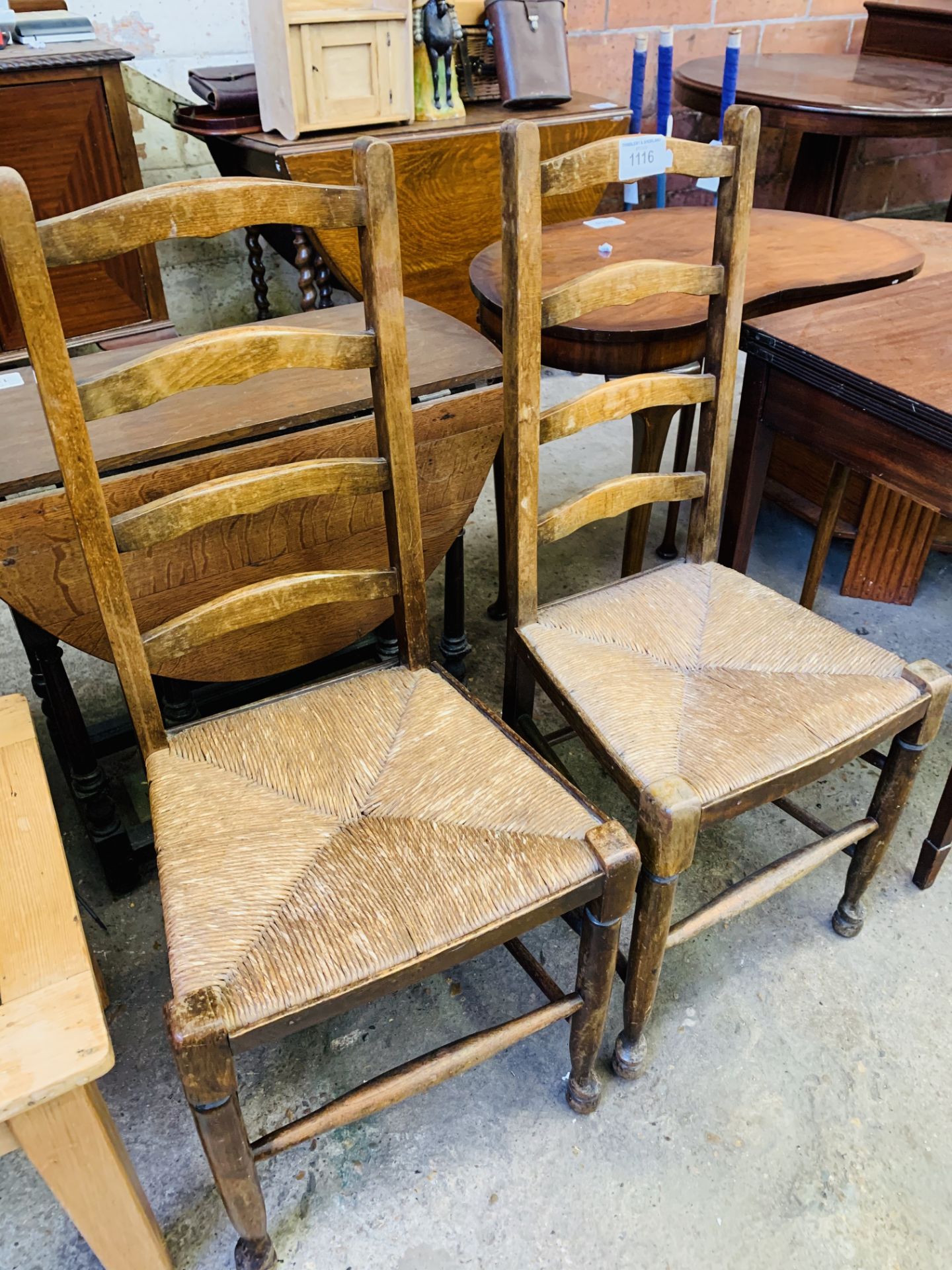 Pair of string seat ladder back chairs.