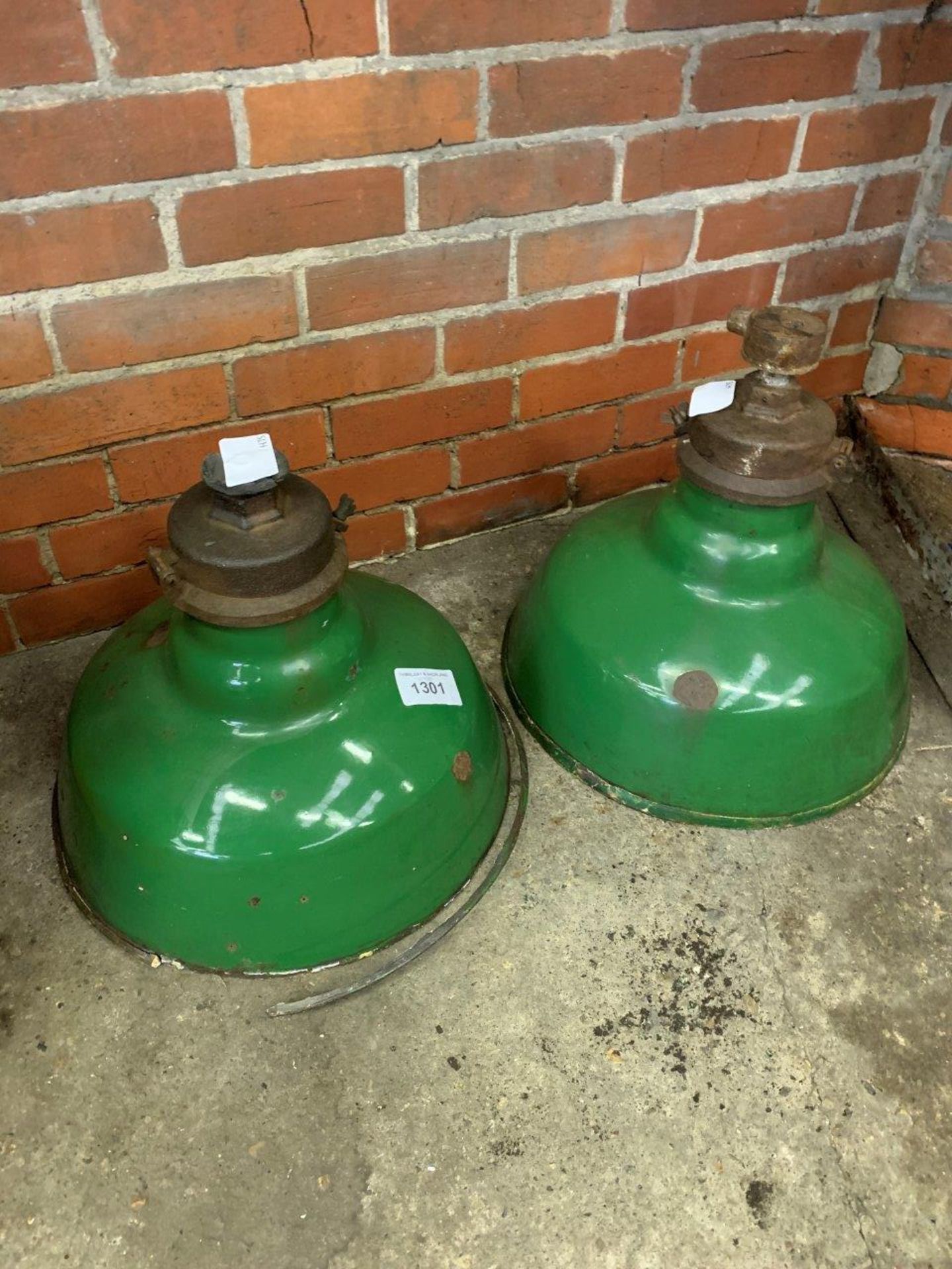 Two large industrial green metal lampshades.