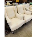 Pair of Victorian wing back upholstered armchairs on casters, requiring loose covers.