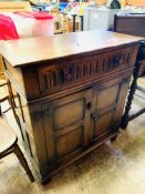 Oak cabinet with carved front and two frieze drawers.