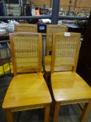 Four pine chairs with rattan back and decoration under seat.