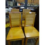 Four pine chairs with rattan back and decoration under seat.