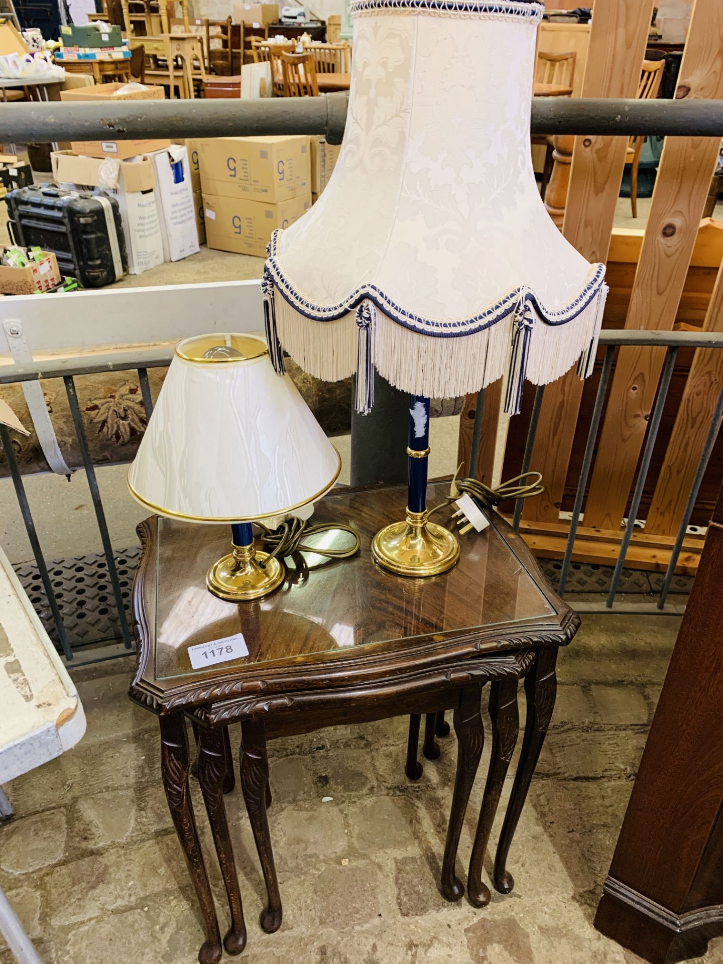 Nest of 3 mahogany tables with glass tops, and 2 brass table lamps