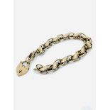 9ct gold link bracelet with padlock, requires repair.