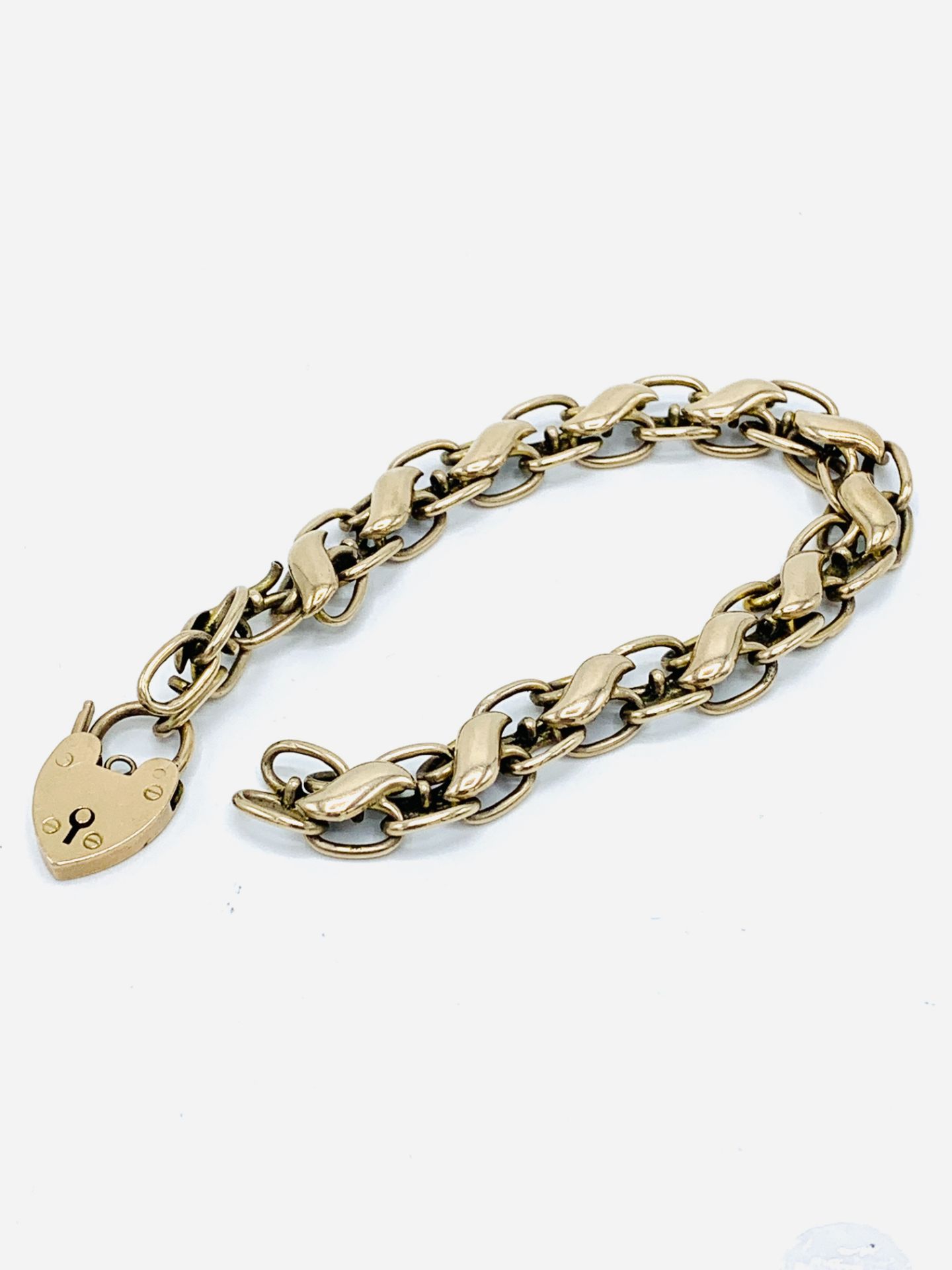 9ct gold link bracelet with padlock, requires repair.