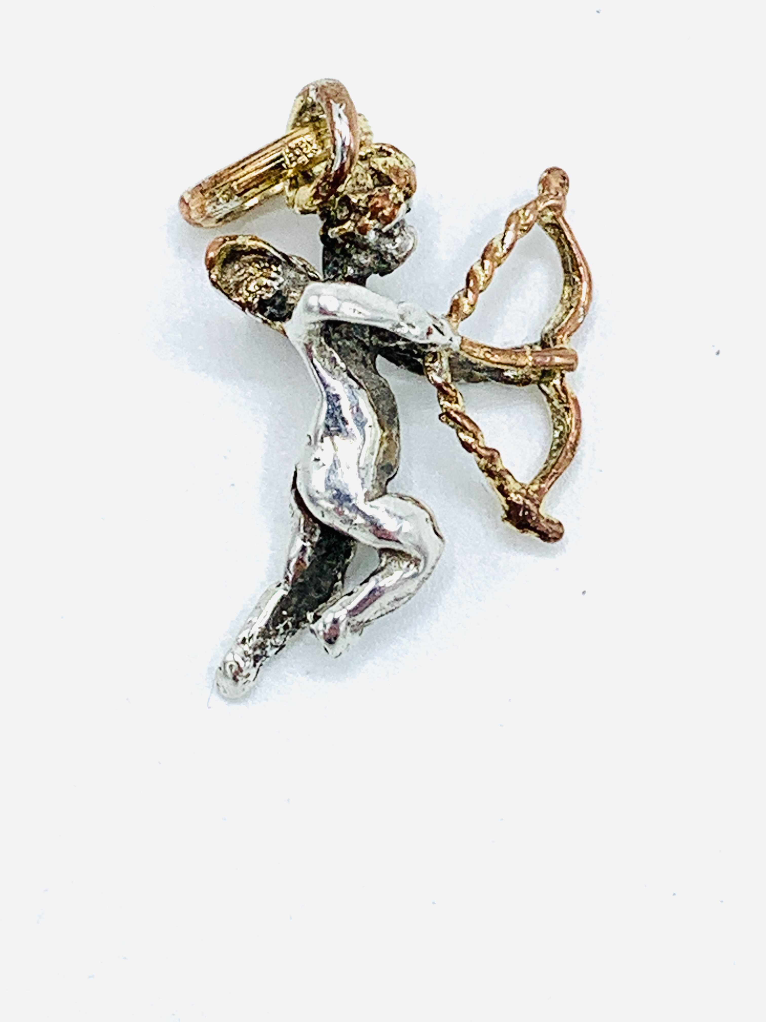 Victorian silver cupid pendant with gilded wings, bow and halo.