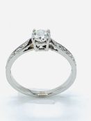 White gold diamond solitaire ring, with diamonds on shoulders.