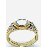 9ct gold ring set with a pale blue topaz stone and white stones on shoulders.