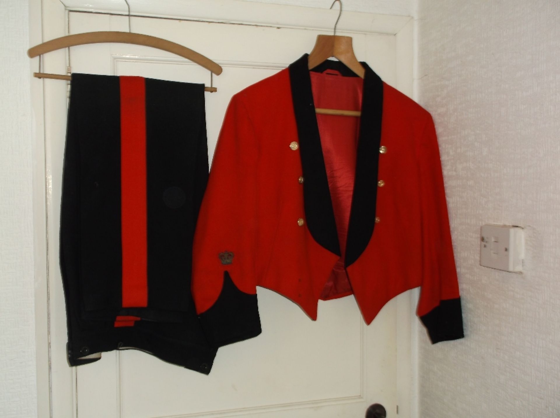 Red and black Royal Signals livery jacket with brass buttons and crest on the sleeves, and matching