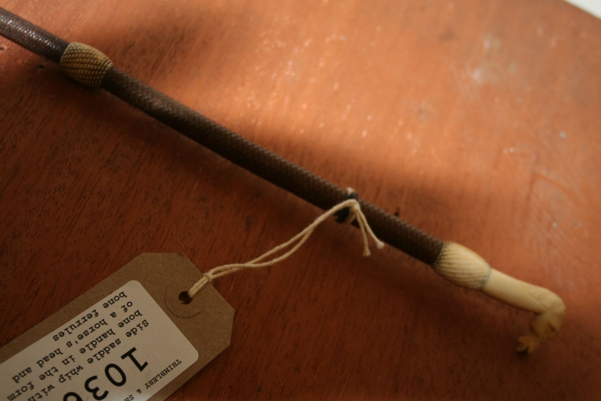 Side saddle whip with a bone handle in the form of a horse's head and bone ferrules