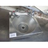 Stainless steel hand wash sink with taps.