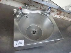 Stainless steel hand wash sink with taps.