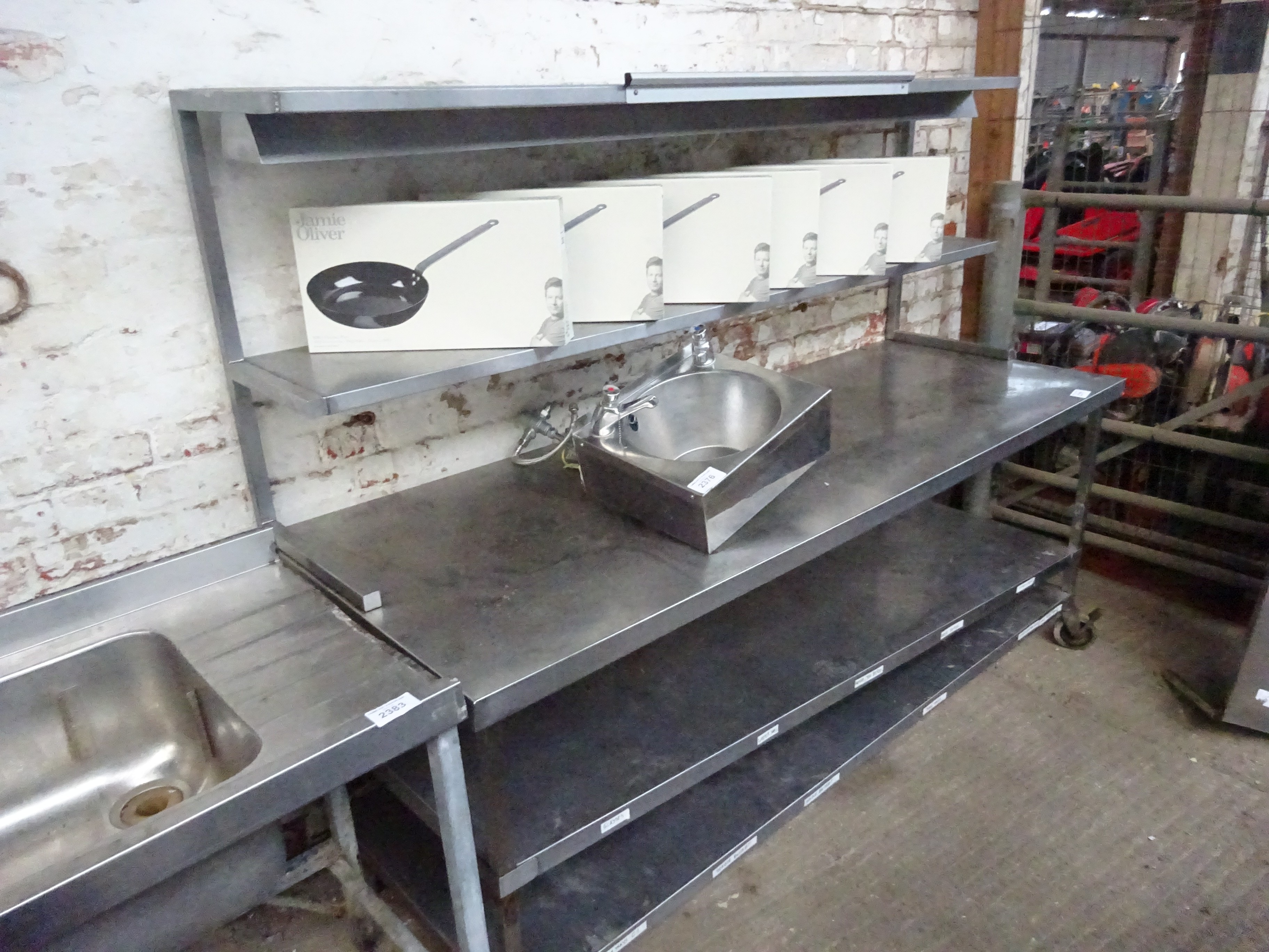 Mobile stainless steel preparation table with under and over shelves.