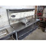 Mobile stainless steel preparation table with under and over shelves.