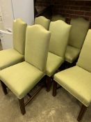Eight high back dining chairs upholstered in pistachio coloured fabric.