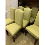 Eight high back dining chairs upholstered in pistachio coloured fabric.